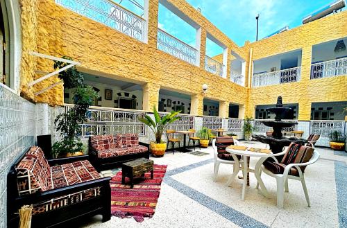 a building with a patio with furniture and a fountain at Hotel Paris in Sousse