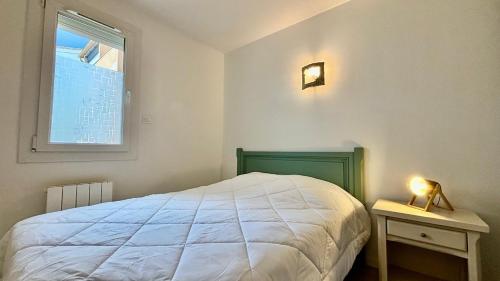 une chambre avec un lit blanc et une fenêtre dans l'établissement Nice 2-room apartment in residence, pool, parking, air conditioning, WiFi, au Cap d'Agde