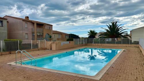 une grande piscine bleue dans une cour dans l'établissement Nice 2-room apartment in residence, pool, parking, air conditioning, WiFi, au Cap d'Agde