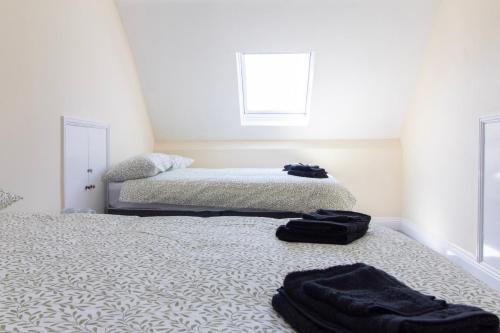 a bedroom with a bed with black towels on the floor at Brookvale Guest House Room 16 in Southampton