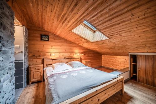 a bedroom with a bed in a wooden room at La Flèche d'Or in Châtel