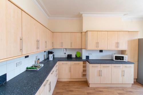 a kitchen with wooden cabinets and black counter tops at Brookvale Guest House Room 16 in Southampton