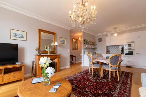 un salon avec une table, des chaises et une télévision dans l'établissement Duchesse - Intramuros - Ascenseur - Coquet - Wifi, à Vannes