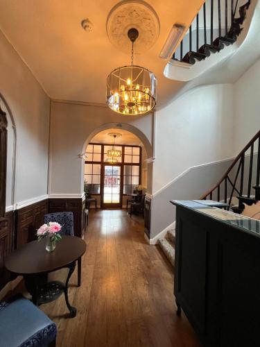 a hallway with a table and a chandelier at Rothwell House Hotel in Kettering