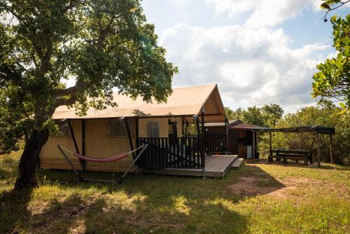 a tent with a hammock in a yard at Eco Glamping Portugal Nature Lodge in São Luis