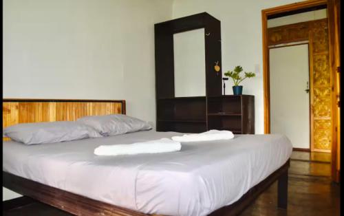 a bedroom with a bed with two towels on it at Pacifico Surf Bayay in San Isidro