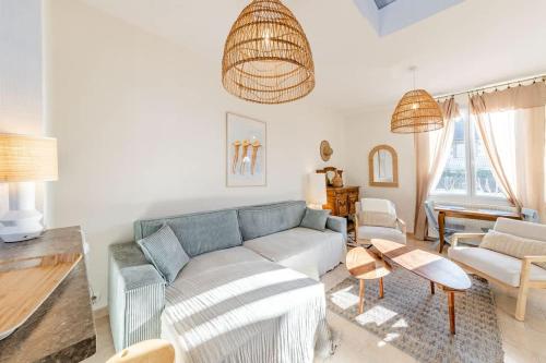 un salon avec un canapé bleu et des chaises dans l'établissement Maison des Embruns - 2 chambres et Jardin clos, à Saint-Malo