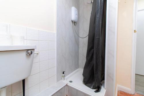a bathroom with a shower with a black shower curtain at Brookvale Guest House Room 17 in Southampton