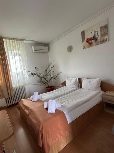 a bedroom with a large bed with towels on it at Motel Dacia in Sebeş