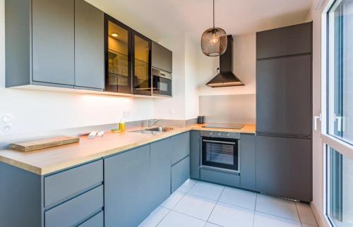 une cuisine avec des armoires bleues et un évier dans l'établissement Le Rio, appartement avec terrasse & parking, à Rennes