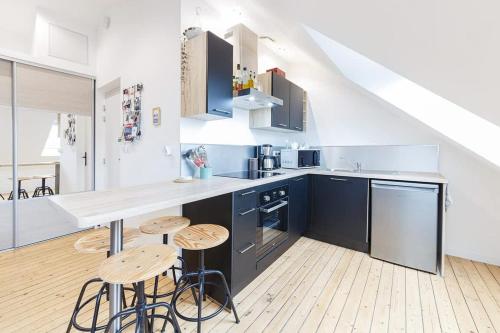 - une cuisine avec un comptoir et quelques tabourets dans l'établissement Cocon Malouin Charmant T2 vue Intra-Muros et port, à Saint-Malo