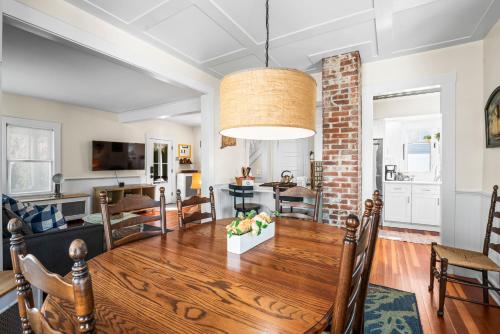 a dining room and living room with a wooden table at Historic Seaside Downtown Mystic Home Walk to Seaport in Stonington