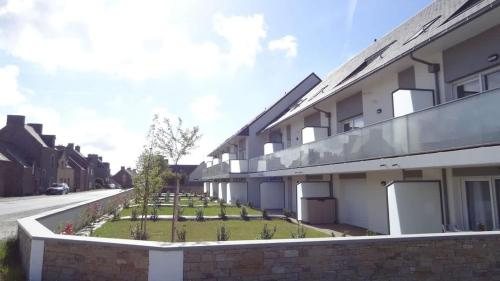 un bâtiment avec un jardin en face dans l'établissement Les Oyats - Appartement 1 chambre - Balcon, à Saint-Coulomb
