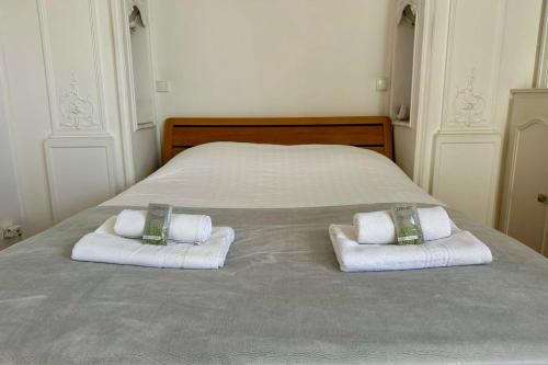 un lit avec deux serviettes et deux oreillers dessus dans l'établissement The Ballon Park- Bright with air conditioning parking and terrace!, à Montpellier