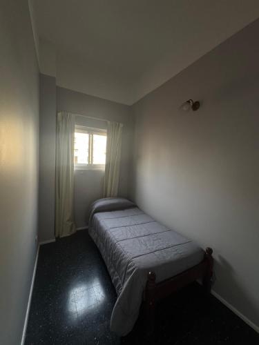 a small bedroom with a bed in a room with a window at Hotel Lyon by MH in Buenos Aires