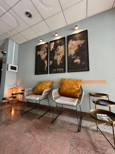 a waiting room with chairs and pictures on the wall at Hotel De Venne in Genk