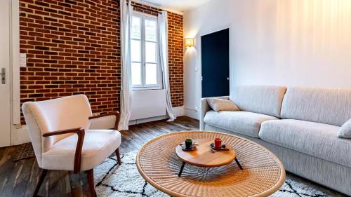 un salon avec un canapé et une table basse dans l'établissement Gare Dijon - Cour Petite Loge, à Dijon