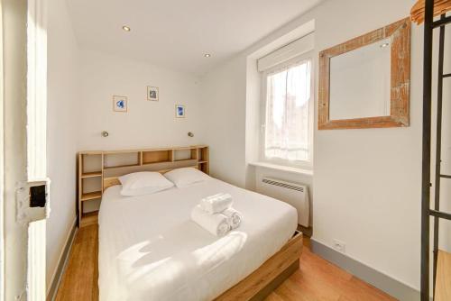 une chambre avec un lit avec deux serviettes dessus dans l'établissement Le Magenta, appartement 2 chambres, proche plage, à Saint-Malo