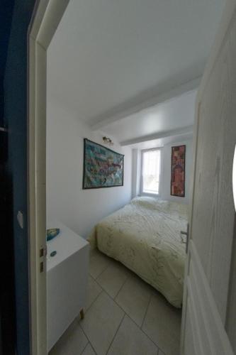 une chambre blanche avec un lit et une fenêtre dans l'établissement Air-conditioned 2-room balcony apartment for 4 people - La Ciotat, à La Ciotat