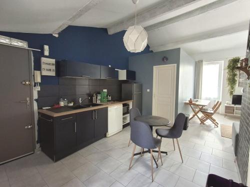 une cuisine avec des murs bleus et une table et des chaises dans l'établissement Air-conditioned 2-room balcony apartment for 4 people - La Ciotat, à La Ciotat