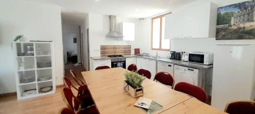 une cuisine avec une table en bois et des chaises rouges dans l'établissement Spacieux duplex 6 Chambres à Azay-le-rideau, à Azay-le-Rideau