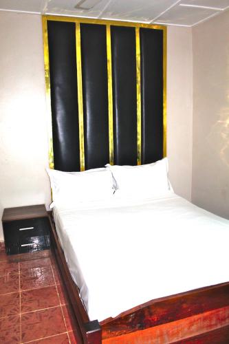 a large bed in a room with yellow and black stripes at Harmony house apartments in Ker Bakary