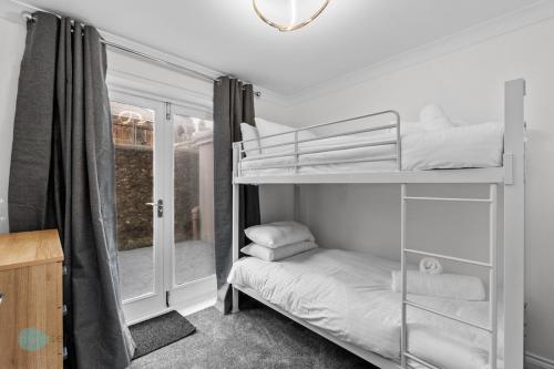 a bedroom with two bunk beds and a window at The Barracks by Pureserviced in Plymouth