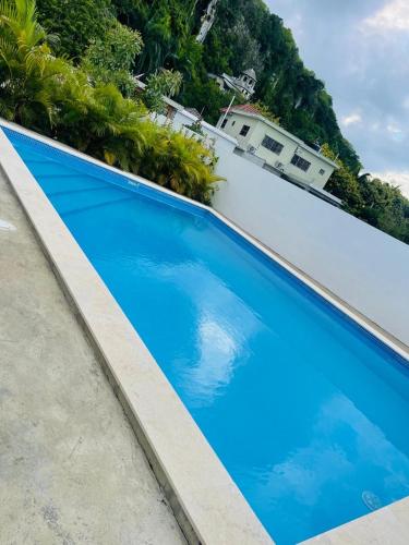 a blue swimming pool with a house in the background at Apartamento Cabrera II in Cabrera