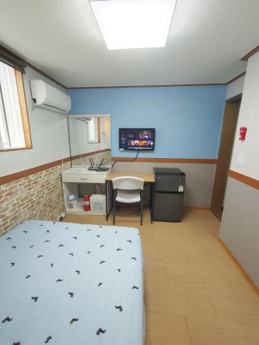 a room with a bed and a table and a kitchen at Sweet House in Seoul