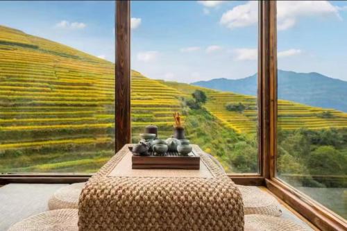 a room with a table with a view of a vineyard at Longji B&B in Cloud in Longsheng