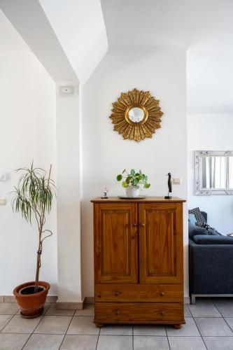 a living room with a wooden cabinet and a mirror at Chez Marraine Suzanne in Liège