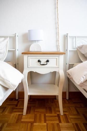 a bedside table with a face painted on it next to two beds at Chez Marraine Suzanne in Liège