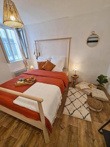 une chambre avec un grand lit avec une couverture rouge et blanche dans l'établissement La Farandole, Spacieux T3 centre historique, à Avignon