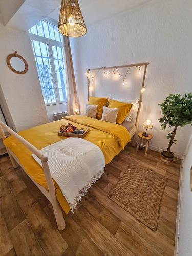 une chambre avec un grand lit avec un couvre-lit jaune dans l'établissement La Farandole, Spacieux T3 centre historique, à Avignon