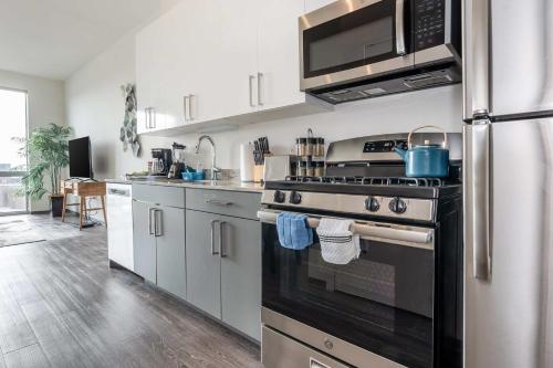 a kitchen with a stove and a microwave at 1BR City Loft With Modern Glass Views in Chicago