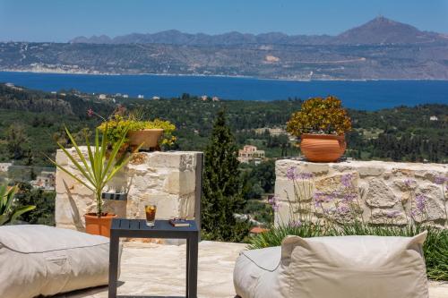 a patio with a view of the water at Villa Anthos - Superb panoramic sea and hill views with private pool in Gavalochori