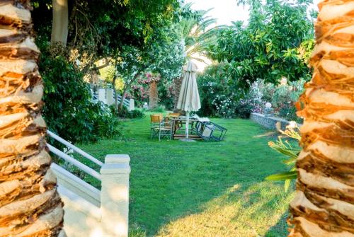 a garden with an umbrella and a table and chairs at Electra Studios in Palaiochóra
