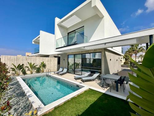a villa with a swimming pool and a house at Elysian Blue villa 3 in Paphos