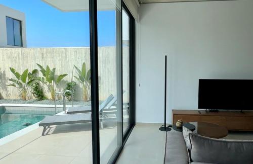 a living room with a television and a swimming pool at Elysian Blue villa 3 in Paphos City