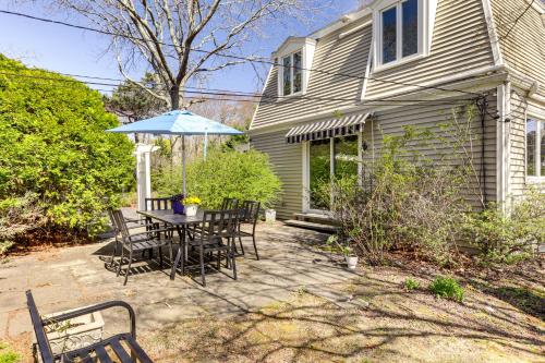 a patio with a table and chairs and an umbrella at 3 Mi to Cape Cod Bay Marshfield Home with Balcony! in Marshfield