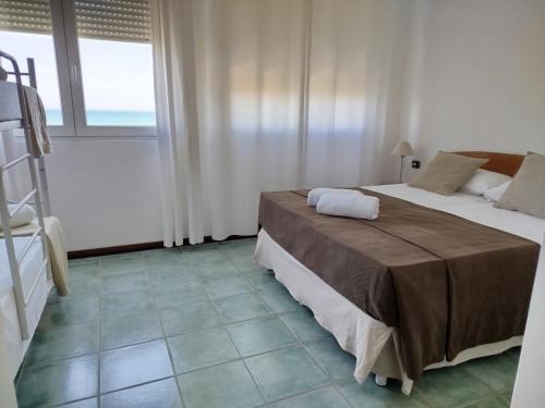 a bedroom with two beds and a large window at Stella Maris Hotel in Ginosa Marina