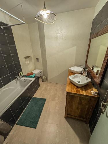 une salle de bain avec un lavabo, une baignoire et un miroir dans l'établissement Cocon Marengo - Studio Cozy de 27m2, à Toulouse