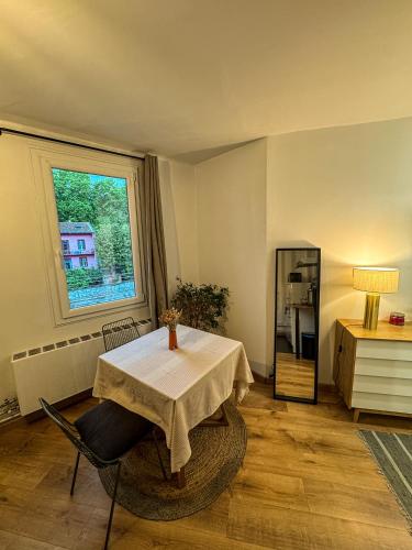 une salle à manger avec une table et un réfrigérateur dans l'établissement Cocon Marengo - Studio Cozy de 27m2, à Toulouse