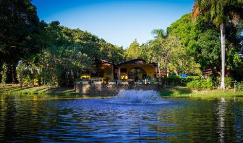 ein Haus inmitten eines Teiches mit einem Springbrunnen in der Unterkunft Hotel Pousada San Marco in Pirapora