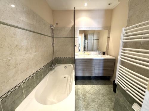 une salle de bain avec une baignoire et un lavabo dans l'établissement ApartHotel Riviera - Hotel des Postes 2 - City center Massena, à Nice