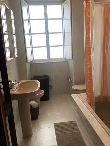 a bathroom with a sink and a toilet and a window at Casa da Miniña in Quilmas