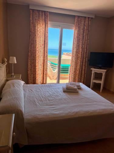 a bedroom with a bed with a view of the ocean at Marbella Beach Resort at Club Playa Real in Marbella