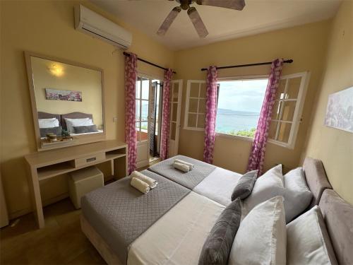 a bedroom with a bed and a large window at Nikos Apartments Corfu in Agios Stefanos