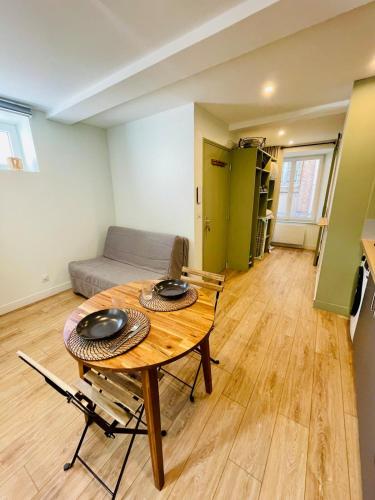 une pièce avec une table, des chaises et un canapé dans l'établissement Studio L'Émeraude, à Tournon-sur-Rhône