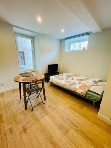 een slaapkamer met een bed en een tafel erin bij Studio L'Émeraude in Tournon-sur-Rhône